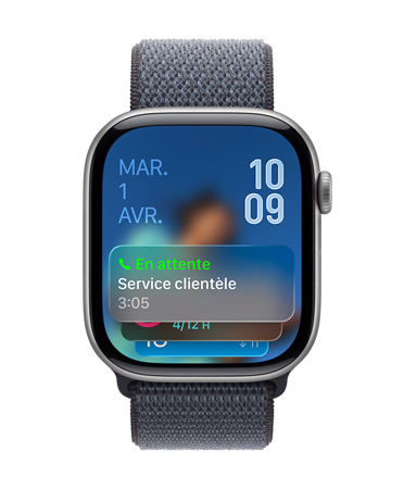Apple Watch noir de jais assortie d’un bracelet de couleur sauge; le bas du cadran affiche une notification d’assistance de mise en attente; la date figure dans le coin supérieur gauche, et l’heure en chiffres superposés dans le coin supérieur droit