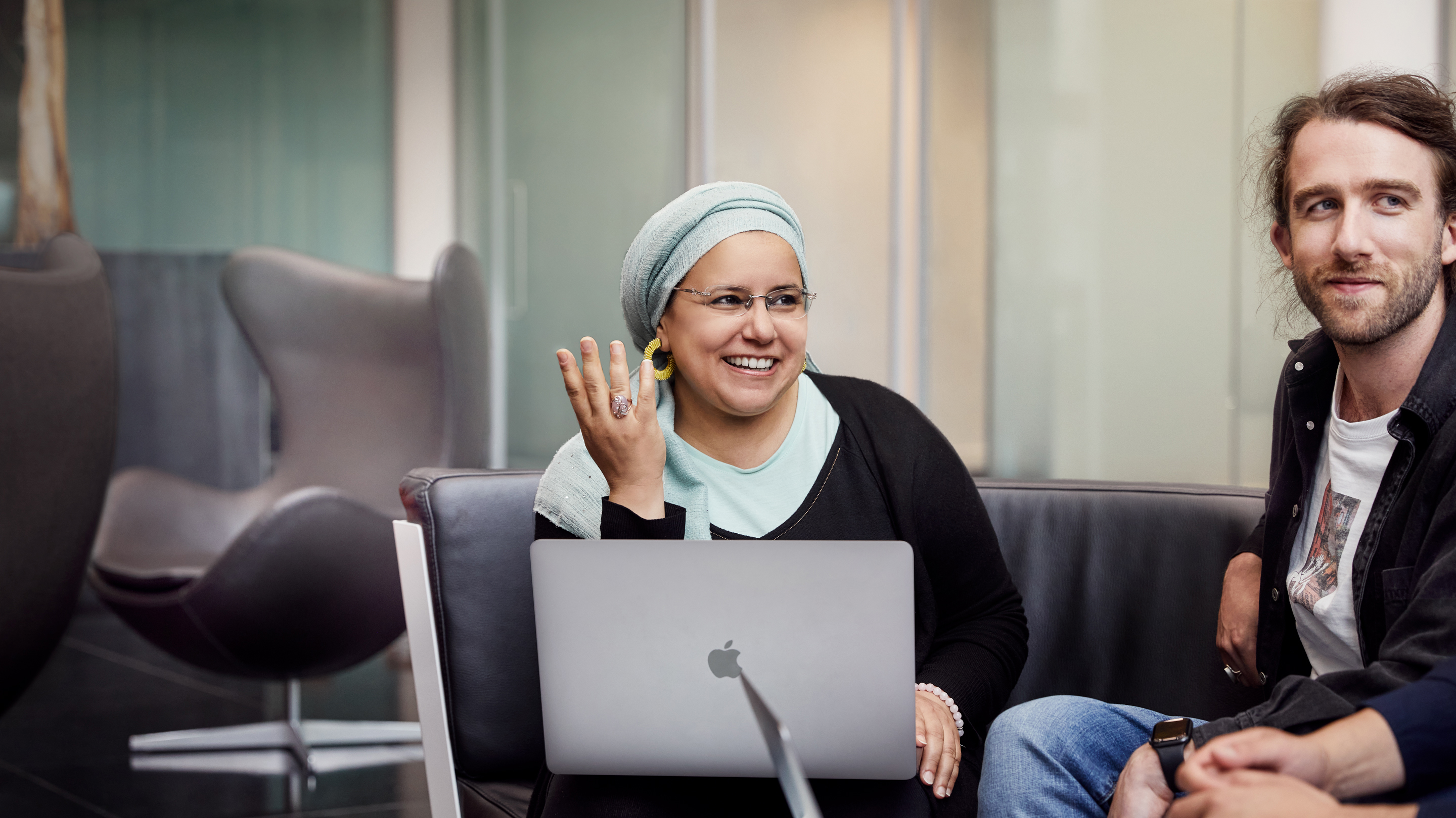 اثنان من موظفي Apple في كورك يجلسان معاً ويتعاونان.