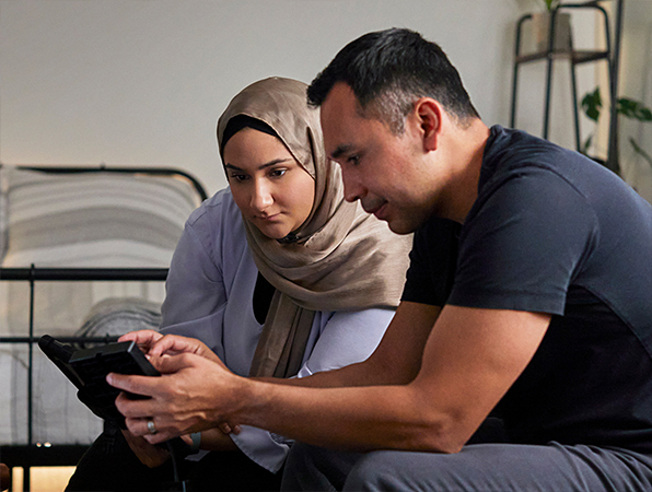 موظفان من قسم التعلم الآلي والذكاء الاصطناعي في Apple ينظران إلى جهاز iPad.