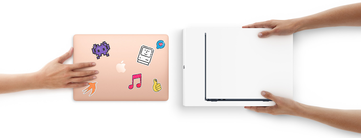 Una mano acerca un MacBook con stickers en la cubierta hacia otras dos manos que sostienen un MacBook nueva dentro de su caja