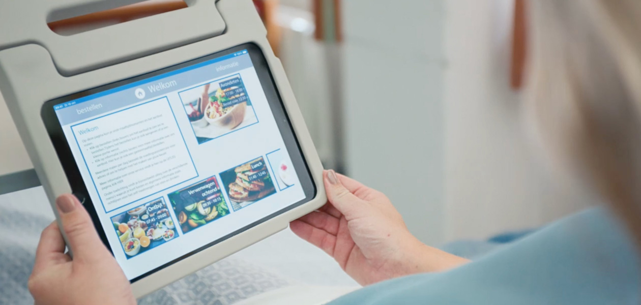 Une patiente dans son lit d’hôpital regarde un écran d’iPad.