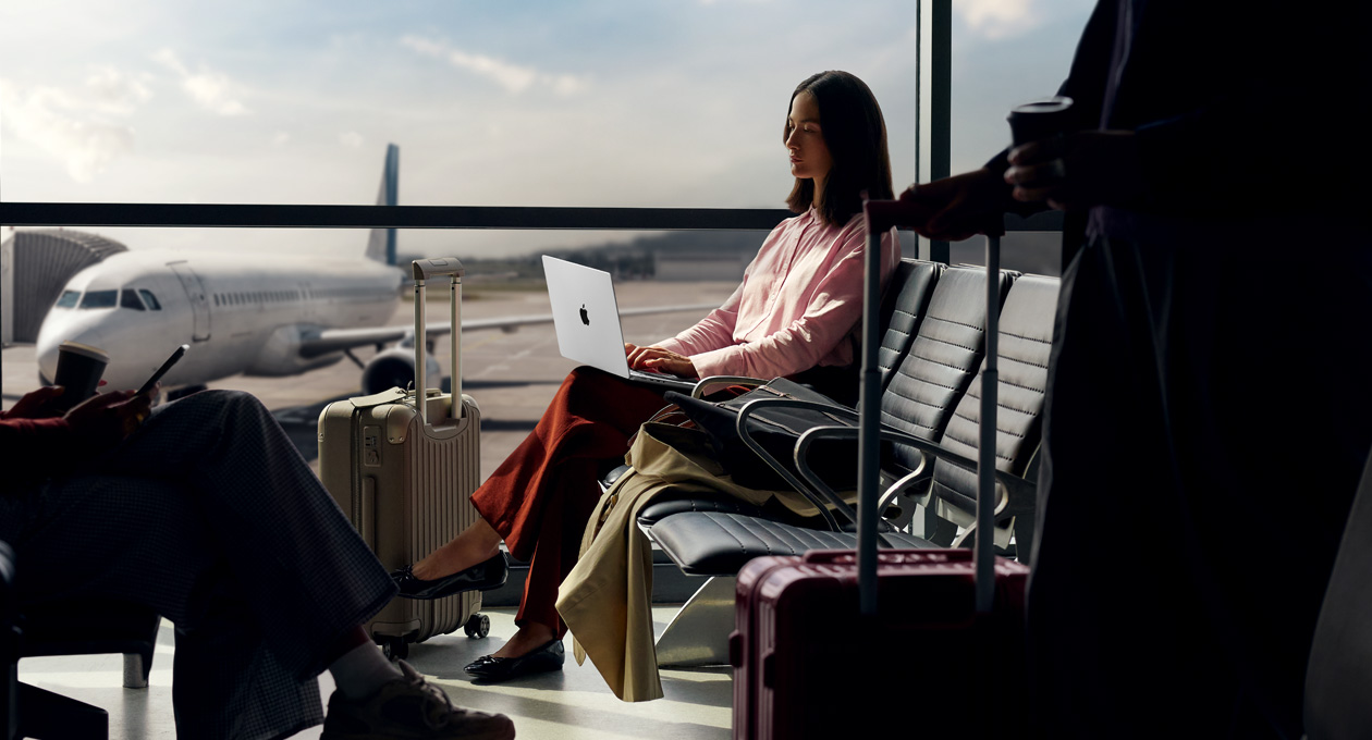 En person bruger sin MacBook Pro i en lufthavn